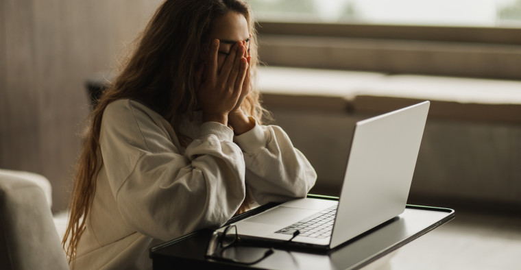 Stressed woman sitting at a computer