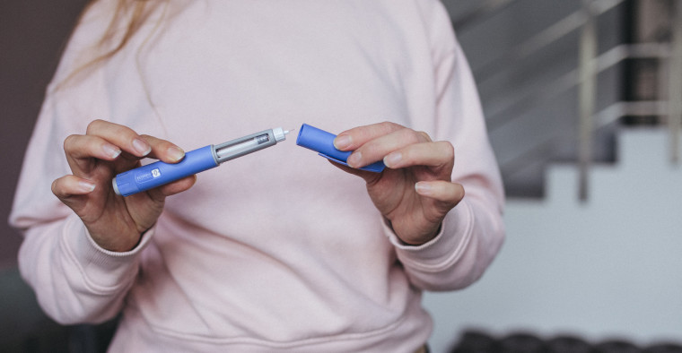 A woman prepares her weight-loss injection pen.