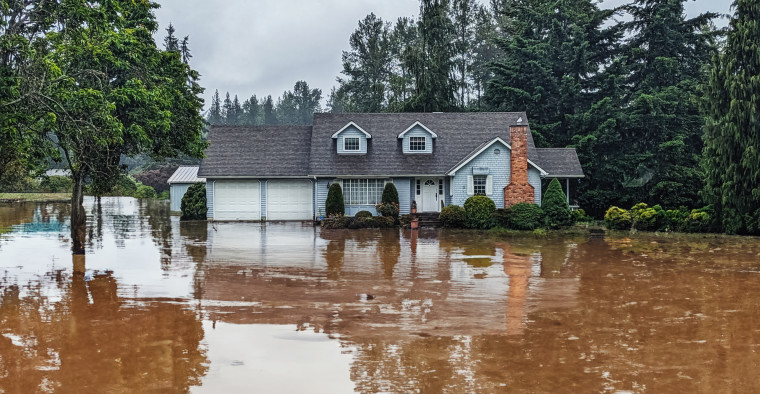 A house's exterior with a flooded yard.