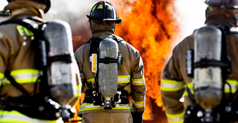 Three firefighters battling flames.