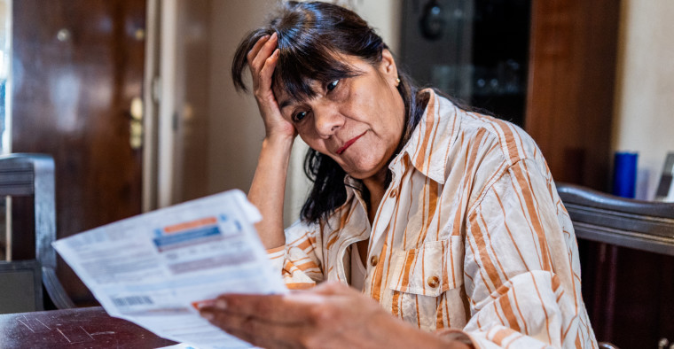 Worried woman looking at medical bills at home