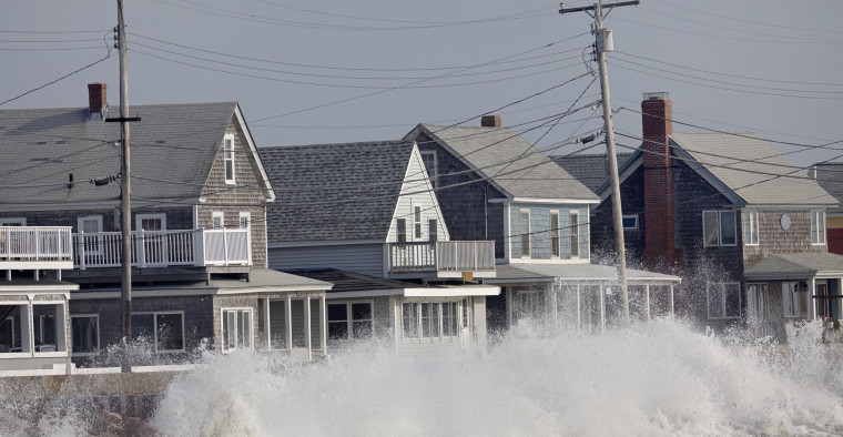 Waves strike a seawall protecting some coastal homes