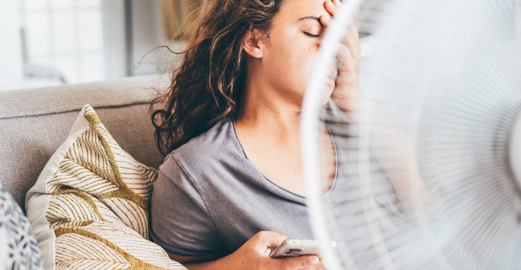 Woman using a fan in her home