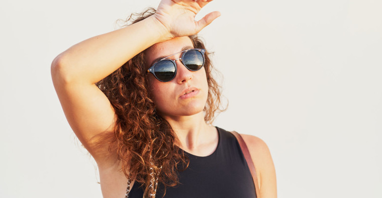 A woman wipes away sweat.