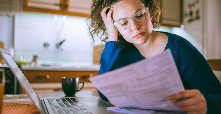 A single woman reviews an insurance bill.