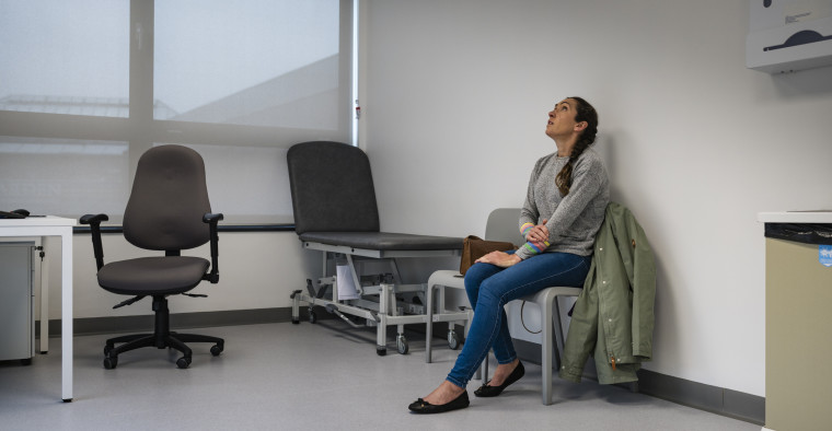 A woman waiting in a doctor's examination room waiting to be seen