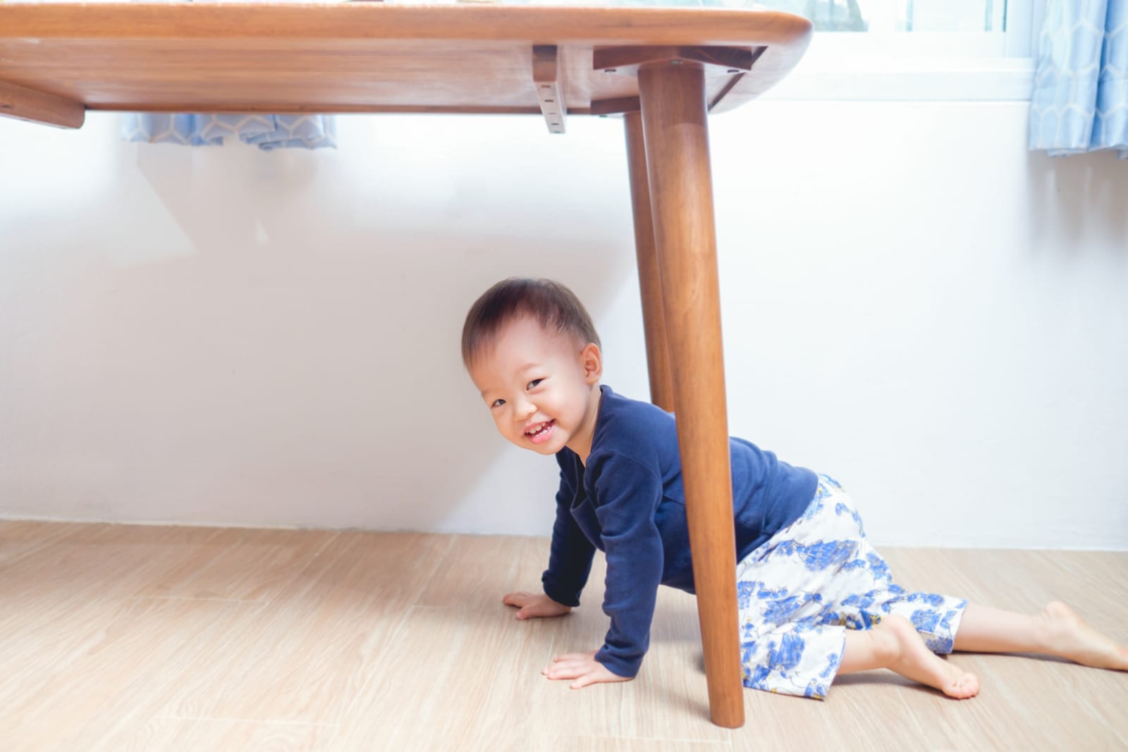 Baby crawling under table