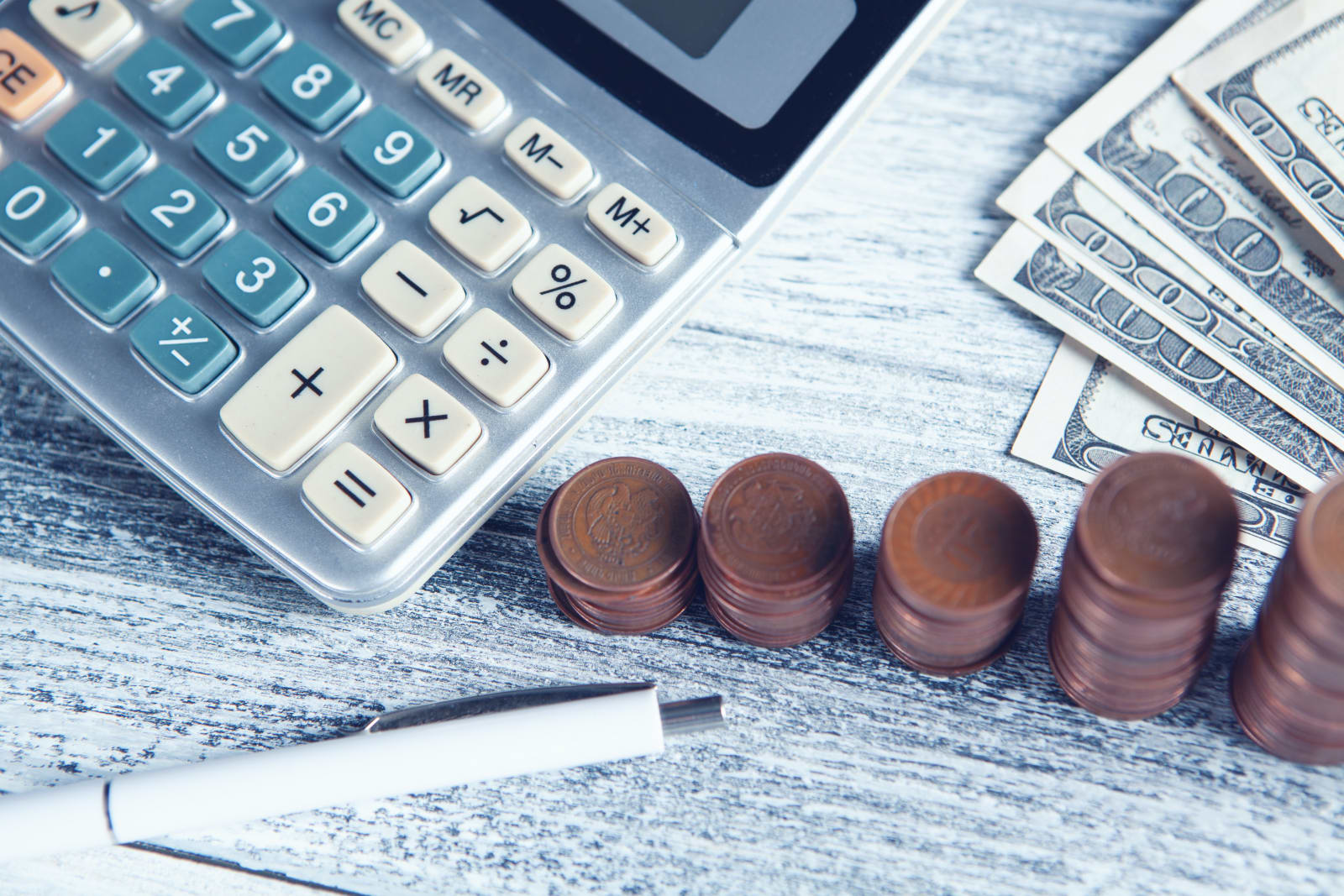 calculator and five stacks of coins