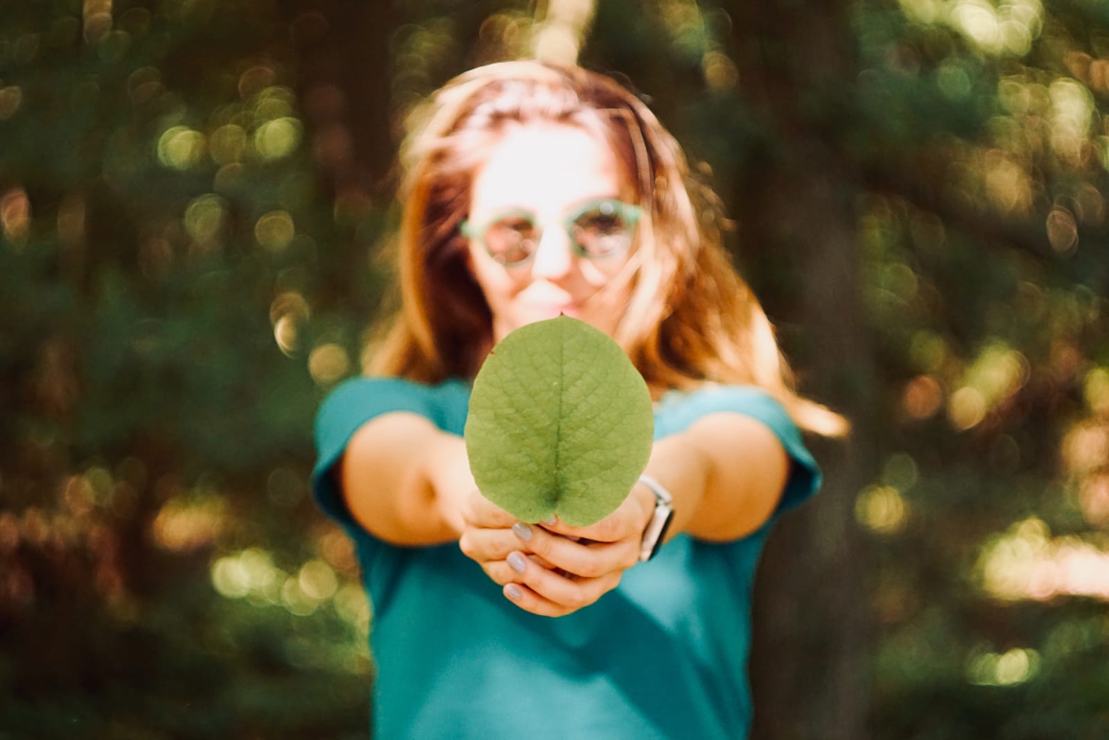 Woman holding a large leaf