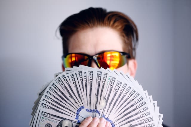 rich man with many hundred dollar bills