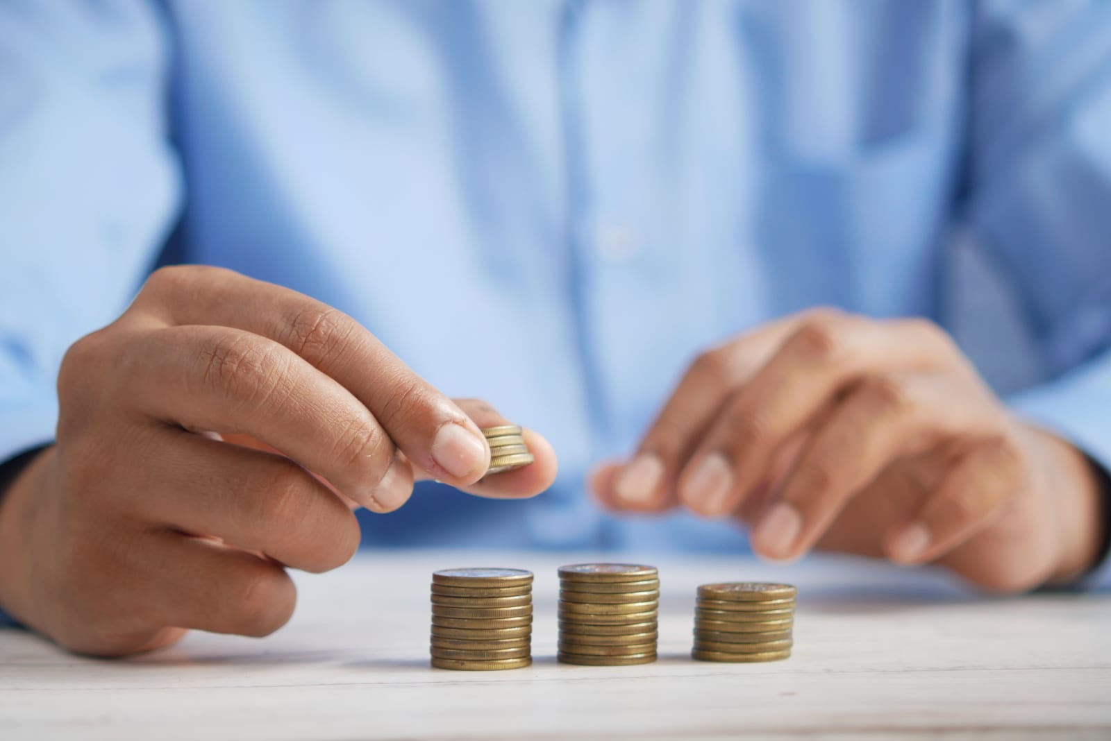 a man stacking three stacks of coins