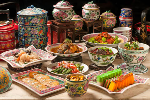 A spread of peranakan dishes served on intricately designed perankan crockery