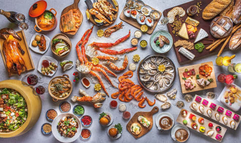 Table filled with different buffet dishes available at Oscar’s @ Conrad