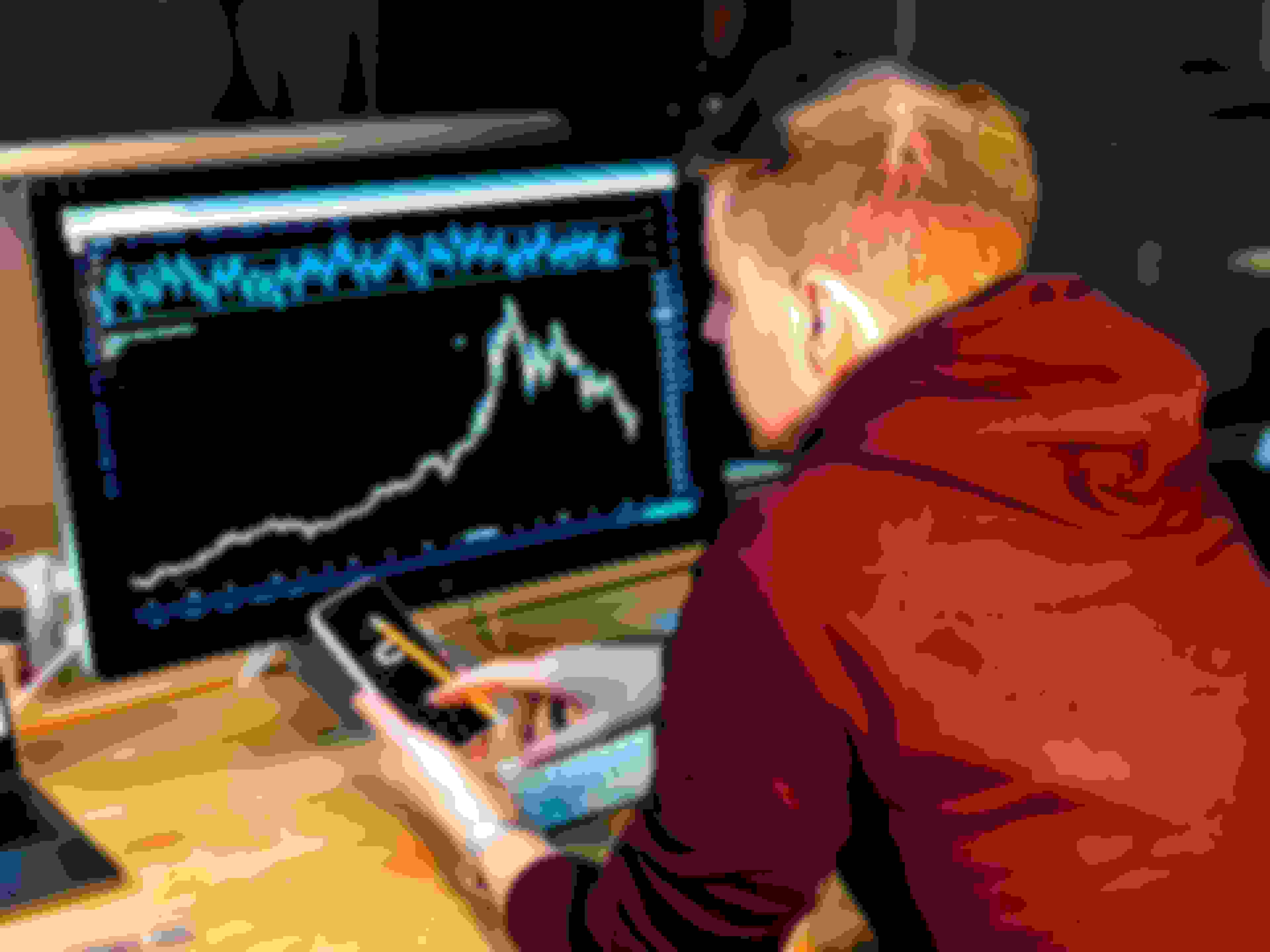 Man looking at trading charts on a computer