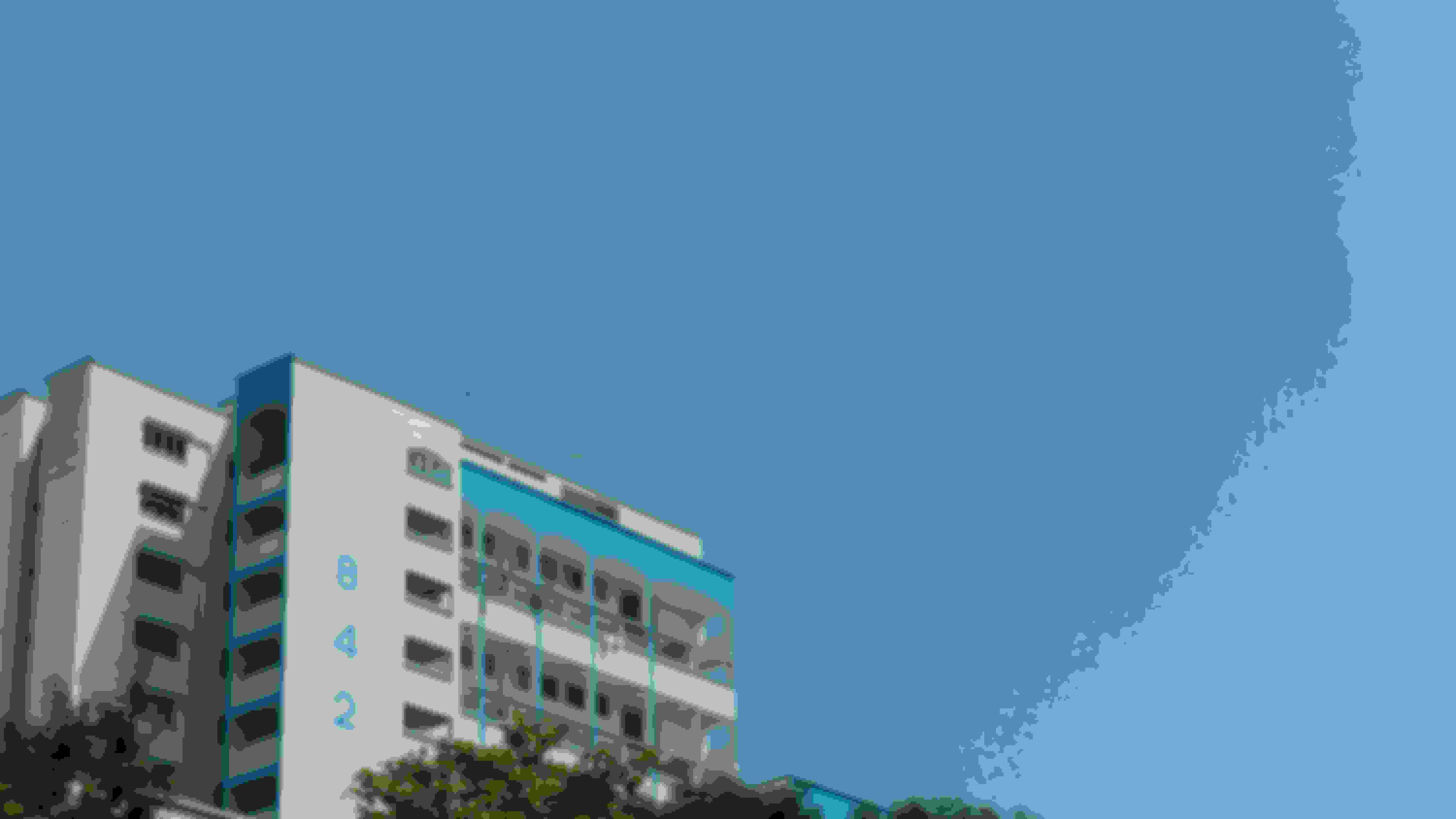 Blue and white HDB Block next to the blue sky