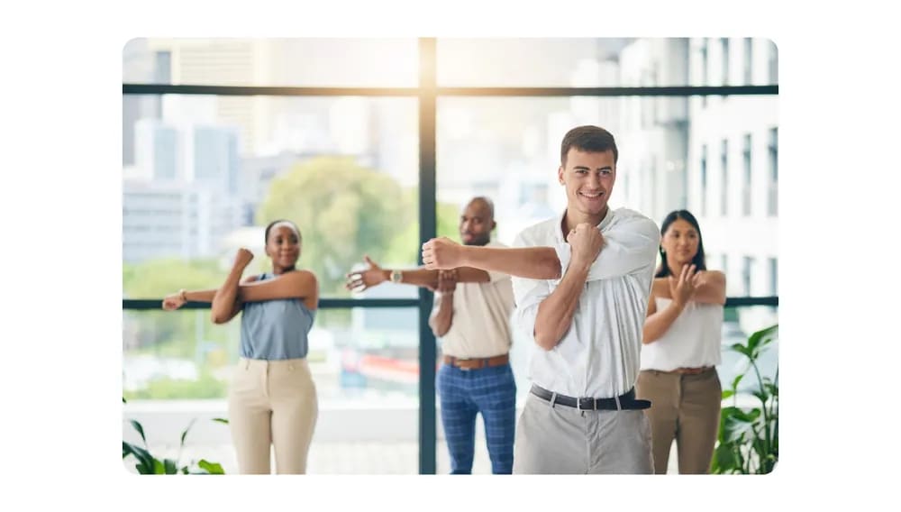 Office employees doing group stretching exercises together in a bright, modern workspace.png