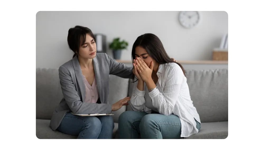 A concerned professional offering support to a distressed colleague during a one-on-one counseling session.png
