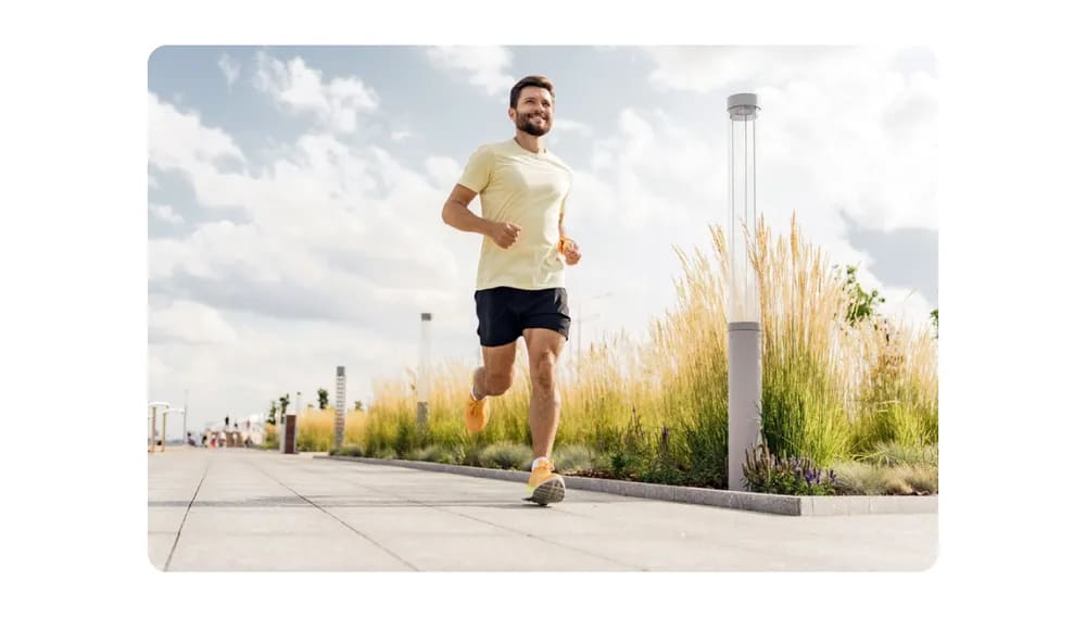 A man running outdoors on a sunny day, showcasing physical activity and fitness.png
