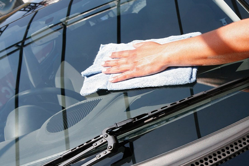 Technician Cleaning Windscreen Glass Before Repairing