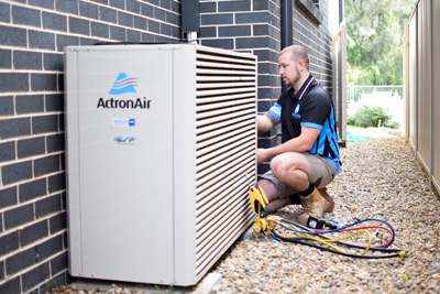 Technician servicing air conditioner unit