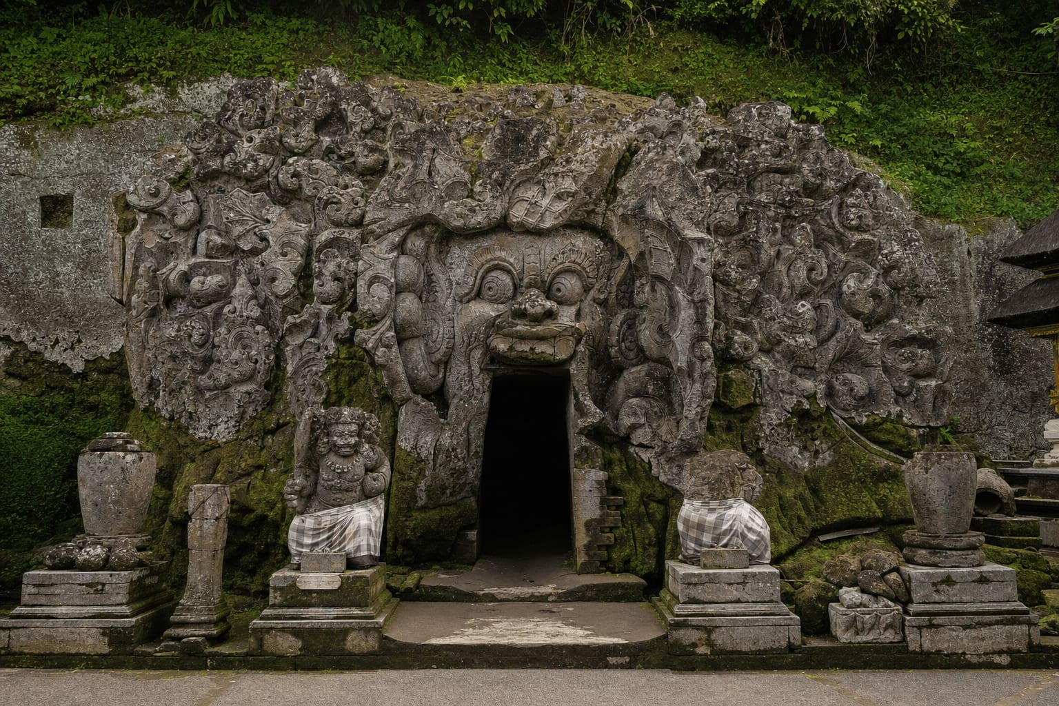 Veetrips Carved cave entrance of the Goa Gajah temple surrounded by greenery