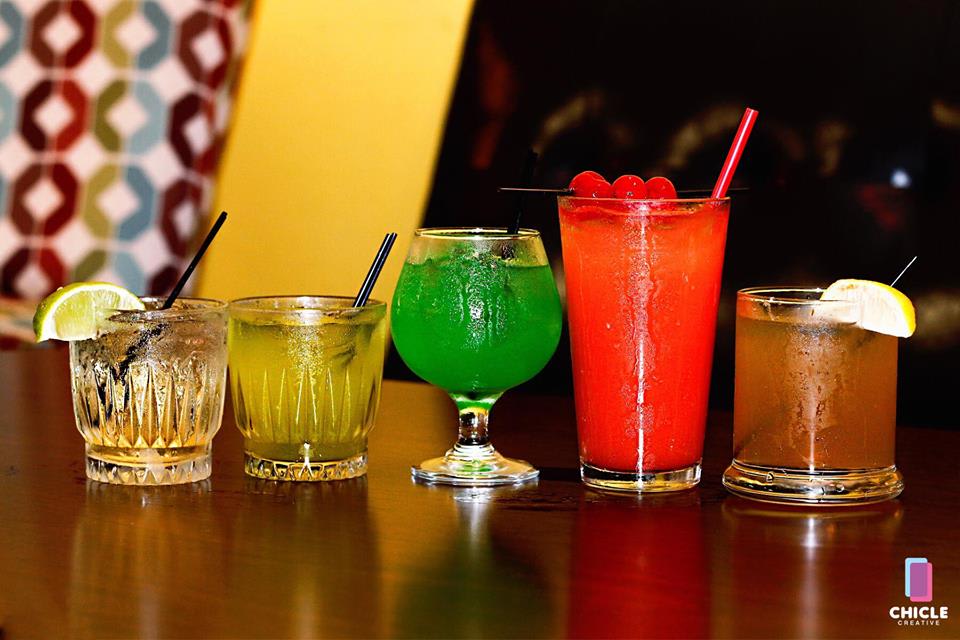 Five colorful cocktails lined up on the bar at Jamaica Jamaica Cuisine