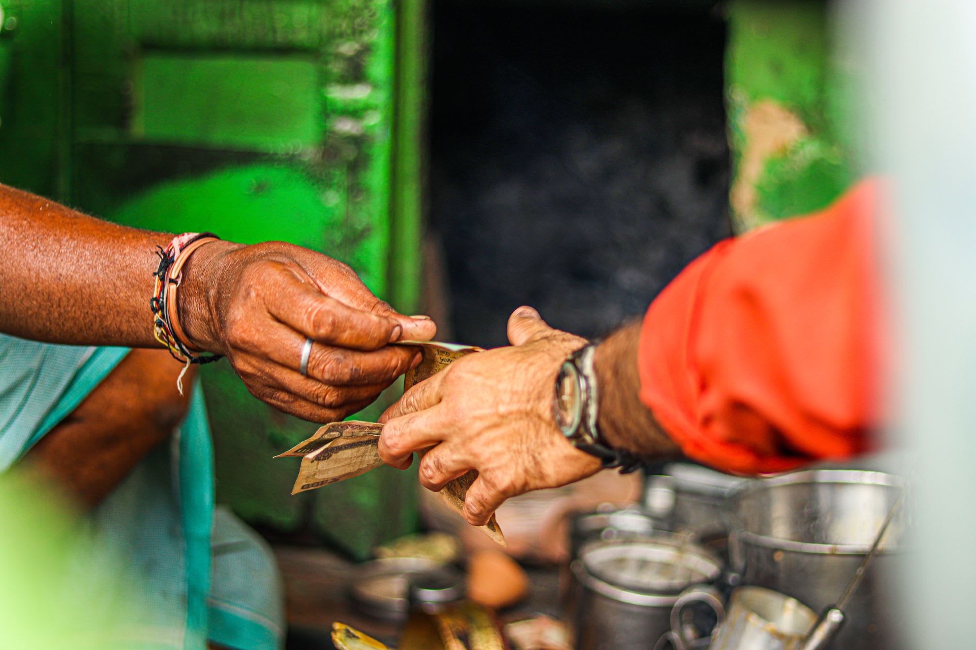 Cash changing hands between a vendor and a customer at a market stall