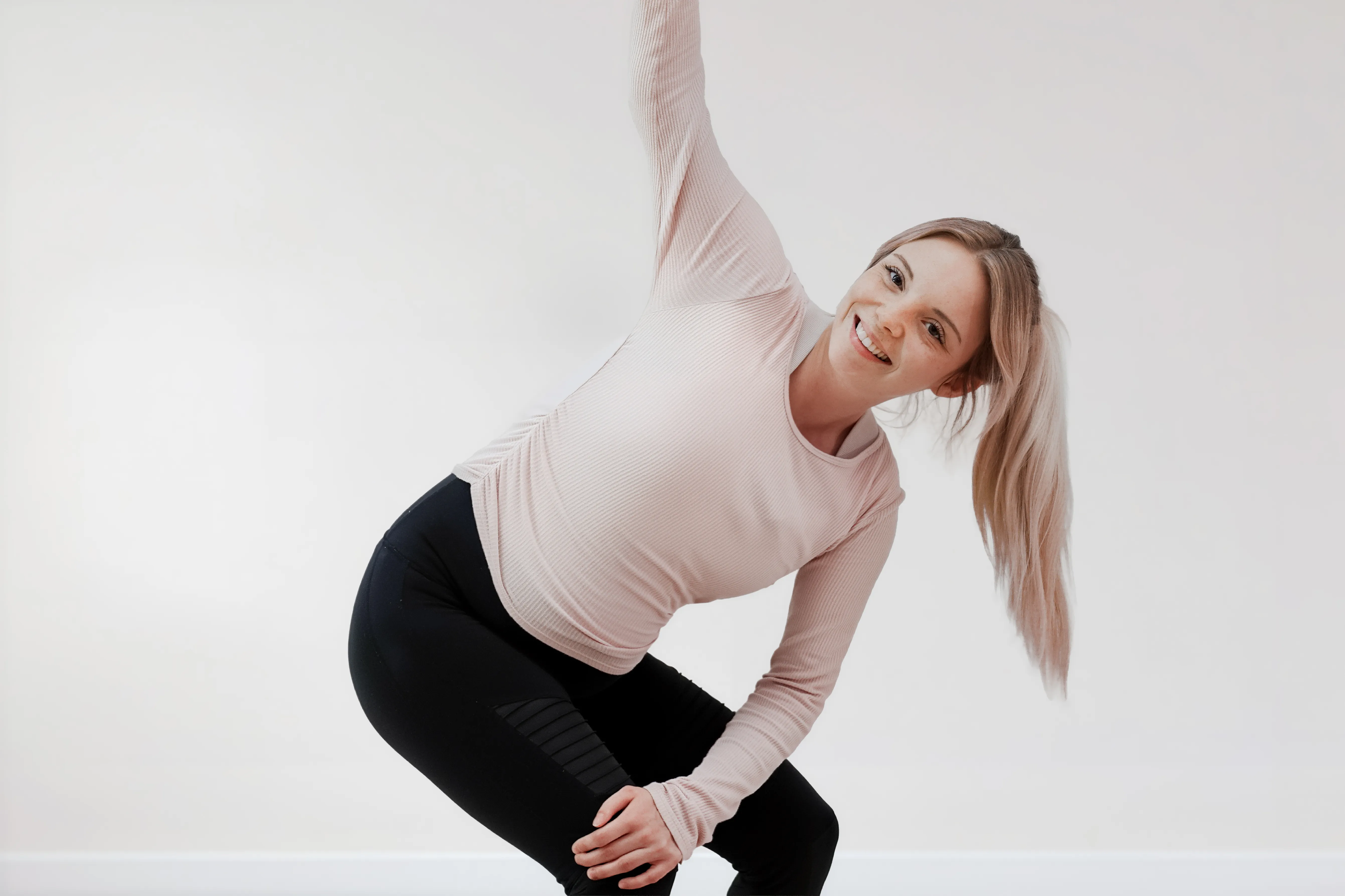 Schwangere Frau macht eine sanfte Yoga-Drehübung im Hatha Yoga für Schwangere Kurs