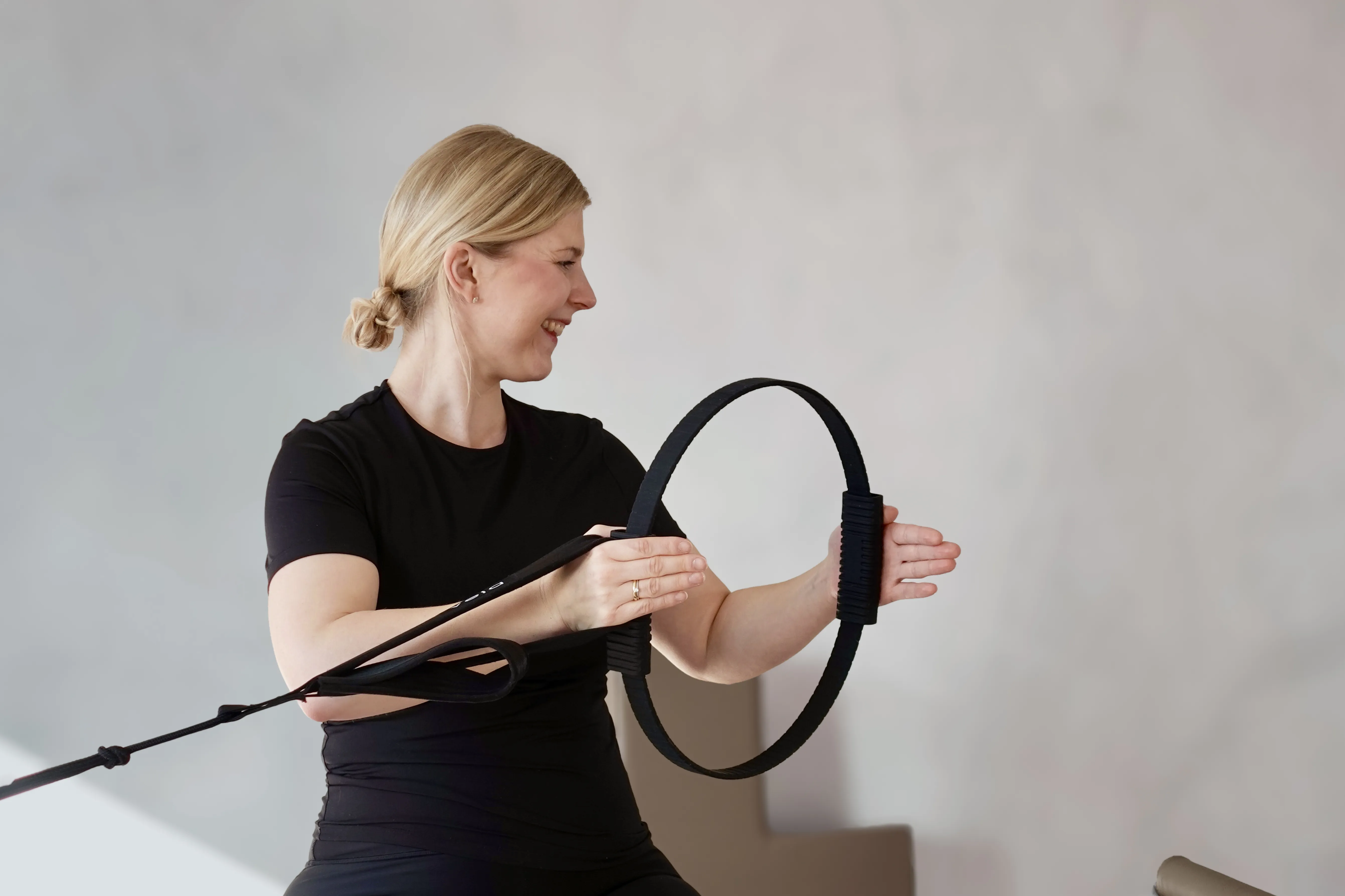 Trainierin benutzt den Pilates Ring auf dem Reformer