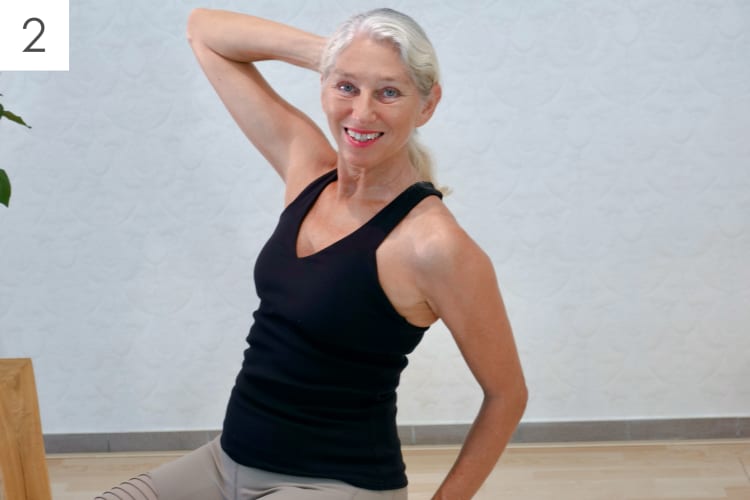 Eine Frau macht Pilates Schulter-Nacken Übungen im Sitzen