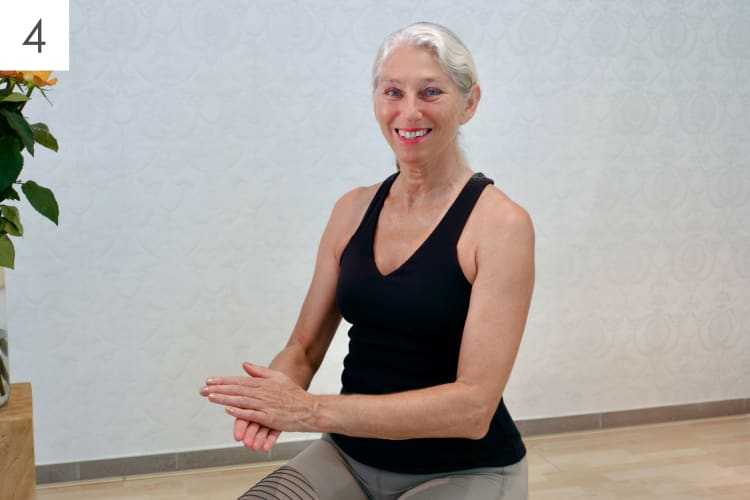 Eine Frau macht Sport Übungen für die Hände und Finger im Sitzen