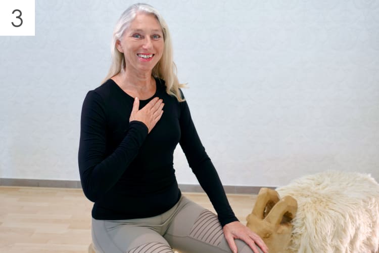 Eine Frau trainiert die Pilates Atmung im Sitzen