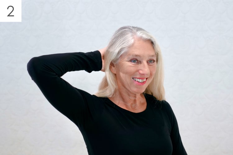 Eine Frau macht Pilates Schulter-Nacken Übungen im Sitzen