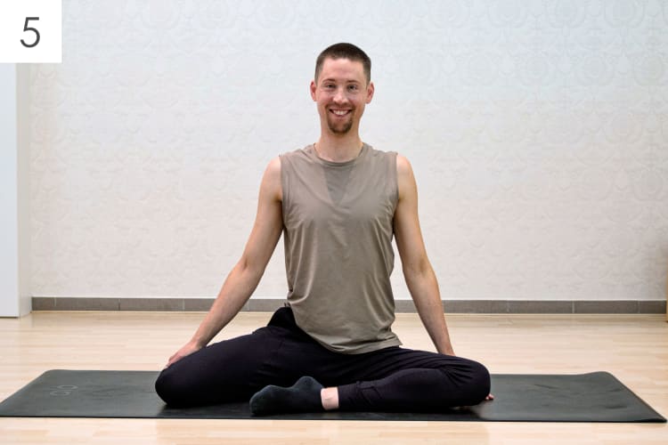Ein Mann macht die Pilates Übung Langsitz