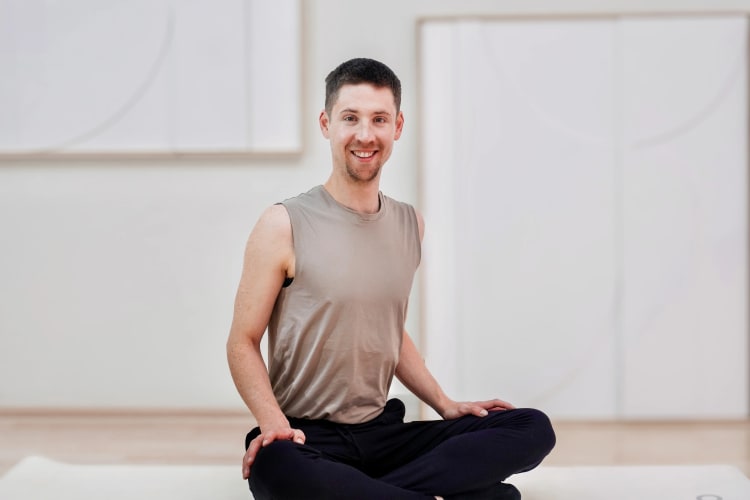 Ein Pilates Trainer lacht beim Training.