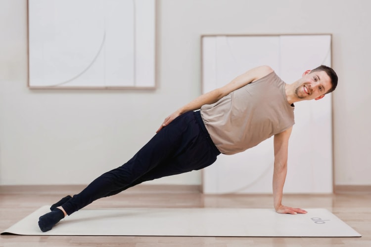 Eine Person macht die Pilates Übung Seitstütz.