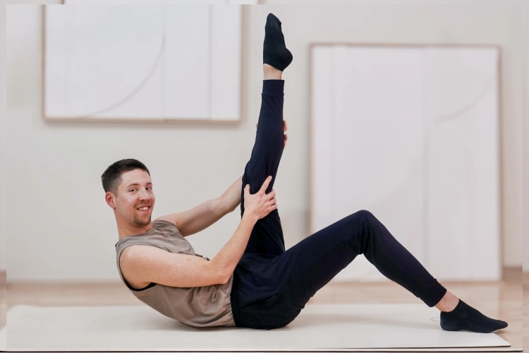 Eine Person macht eine Dehnungs Pilates Übung.