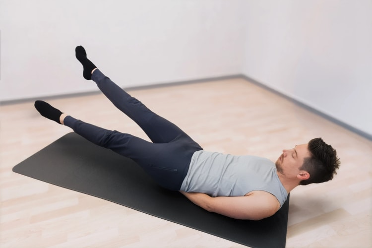 Ein Mann macht Pilates Flutter Kicks
