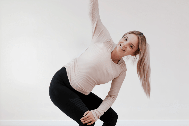 Schwangere Frau macht eine sanfte Yoga-Drehübung im Hatha Yoga für Schwangere Kurs