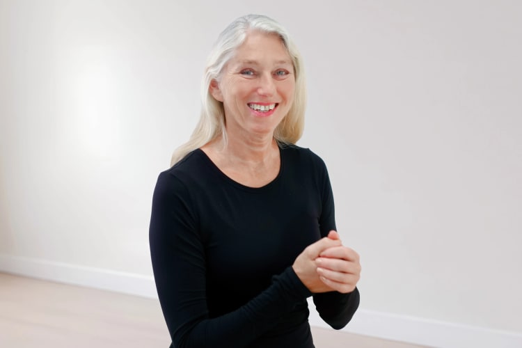 Eine Frau macht Sport Übungen für die Hände und Finger im Sitzen