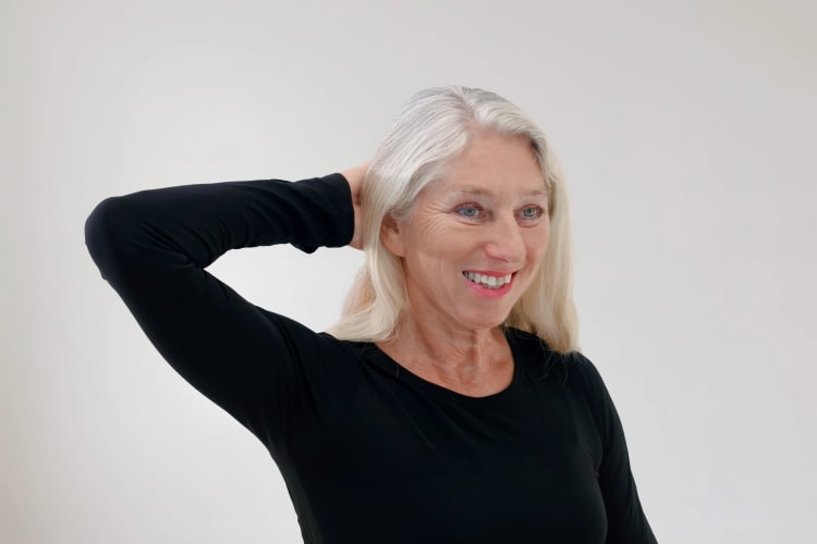 Eine Frau macht Pilates Schulter-Nacken Übungen im Sitzen