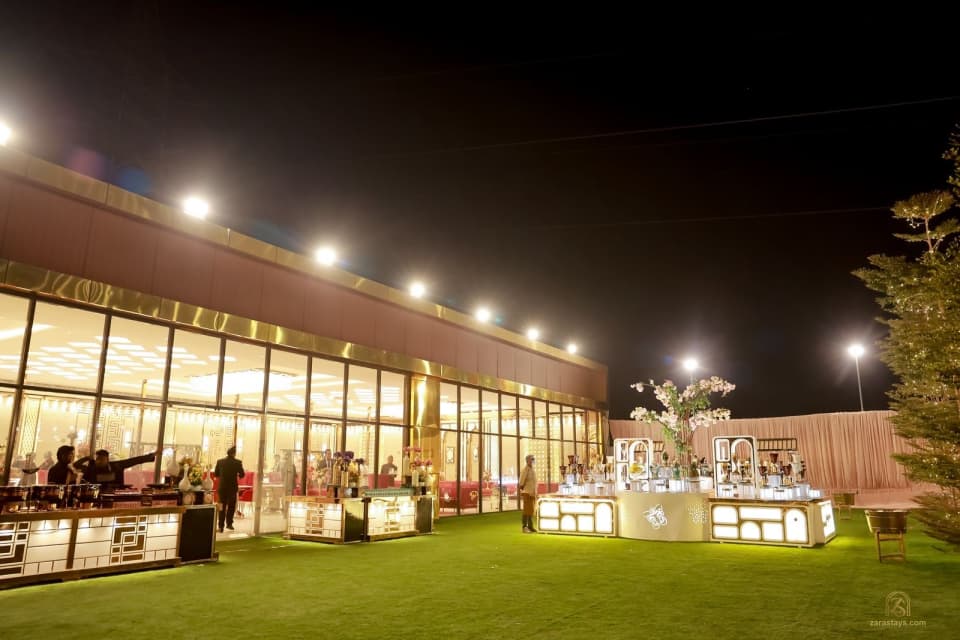 Lawn beside a glass-fronted event hall at night
