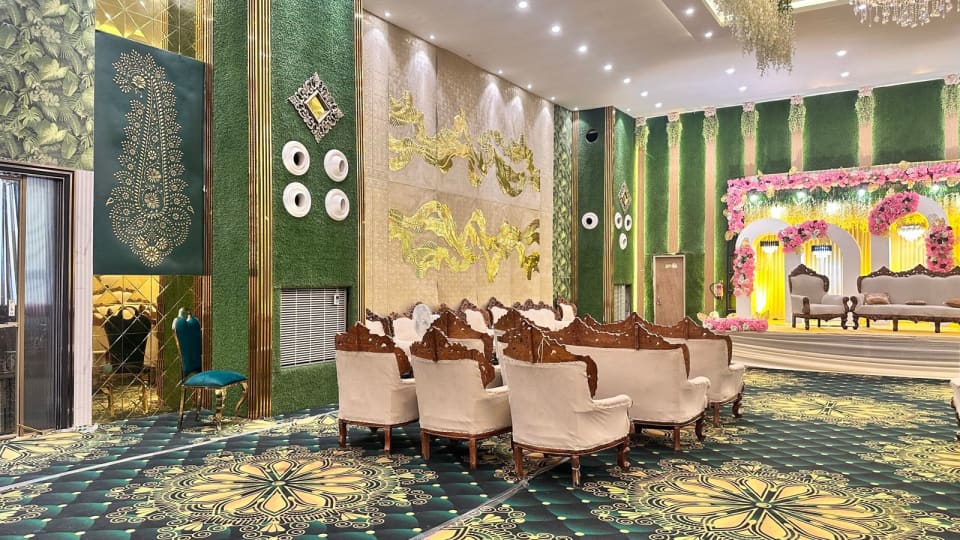 Auravia event hall with green wall panels and a decorated stage