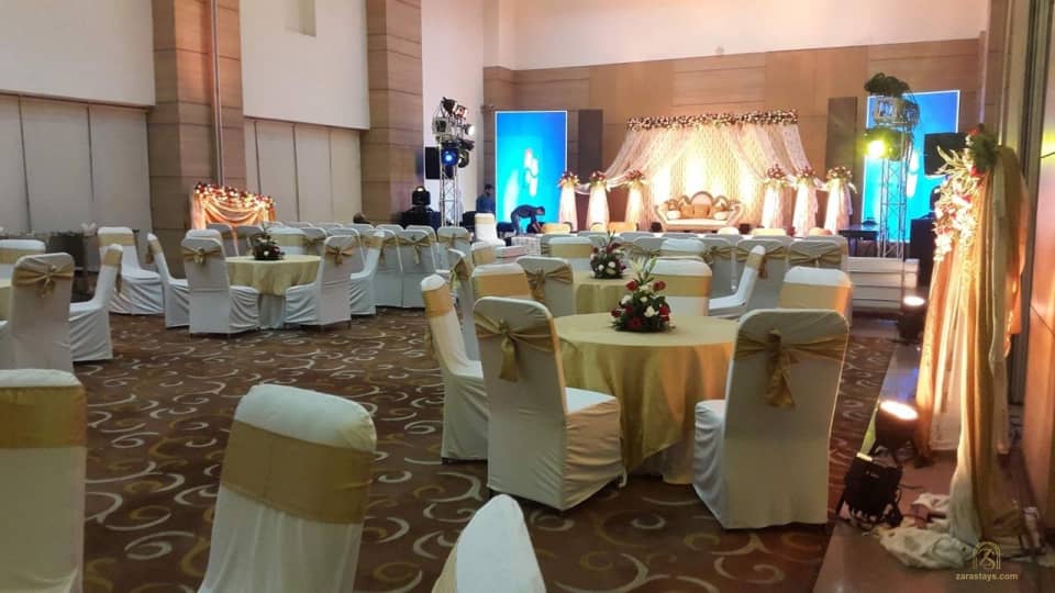 Banquet hall with round tables and a decorated stage