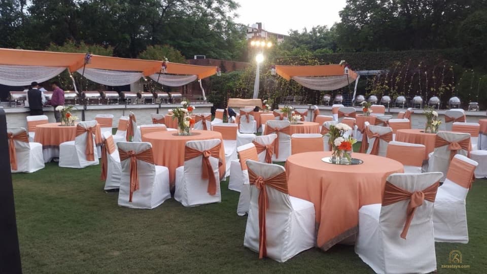 Lawn arranged with covered chairs and round tables