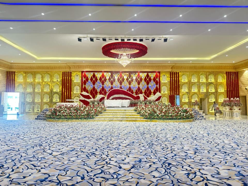 Wide carpeted hall facing a decorated stage