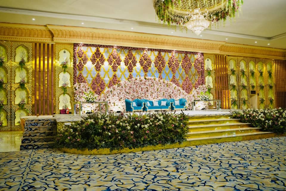 Floral stage beneath chandeliers