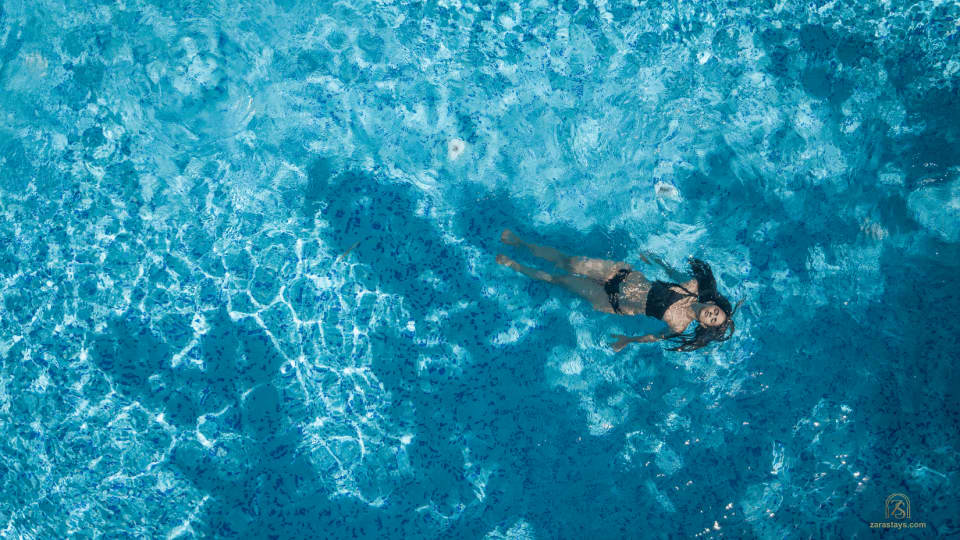 A guest swimming in the pool at Tendu Leaf Jungle Resort & Spa