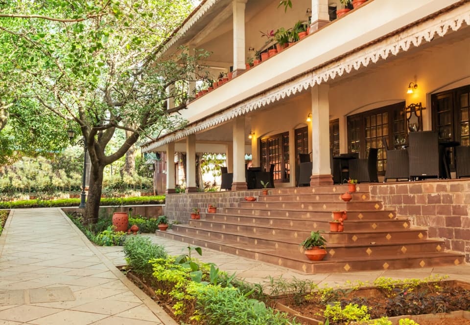 Guest rooms opening onto a leafy verandah at WelcomHeritage Golf View