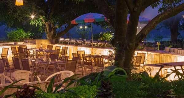 Outdoor dining beneath garden trees at WelcomHeritage Golf View